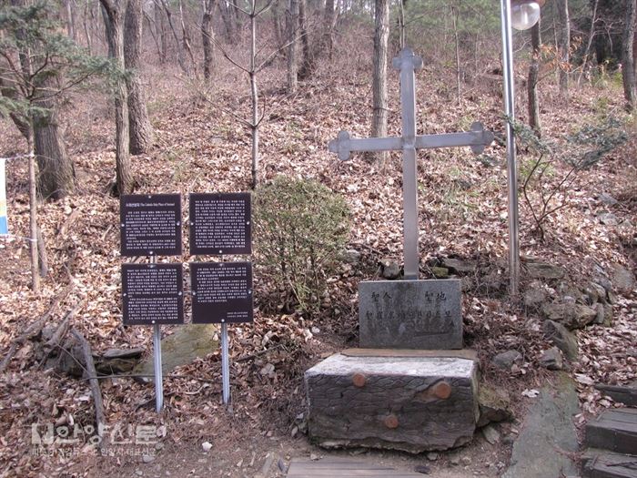 최경환 성인의 묘역으로 가는 입구에는 수리산성지의 의미가 기재된 현판과 십자가가 세워져 있다.